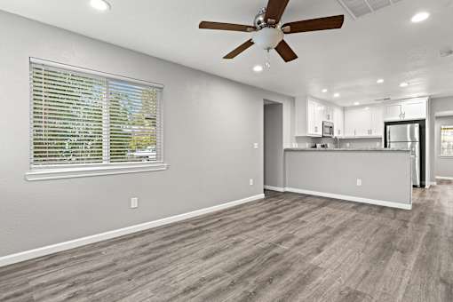 A room with a ceiling fan and a window with blinds.at OSM Properties Homes & Apartments, California  