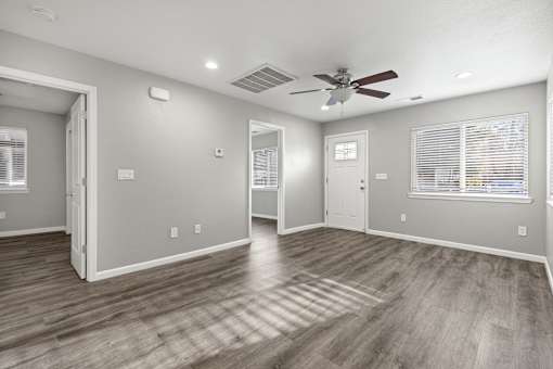 A room with a ceiling fan and hardwood floors.at OSM Properties Homes & Apartments, Chico, CA 95926  