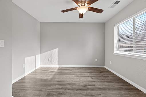 A room with a ceiling fan and a window with blinds.at OSM Properties Homes & Apartments, Chico, CA 95926  