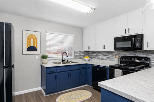 Kitchen with marble countertops and modern backsplash at Pomona Townhomes Apartments, Chico, 95928