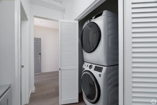 a hallway with a stacked washer and dryer