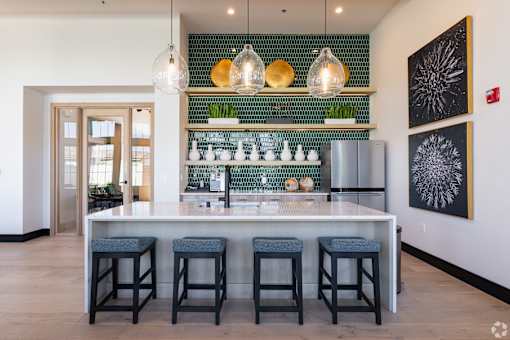 A bar area with a green tile backsplash and a white counter.
