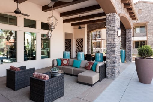 a covered patio with couches and pillows