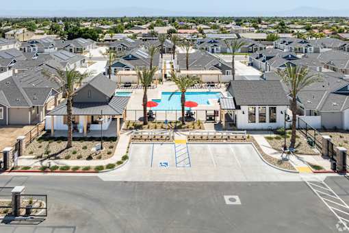 A view of a residential area with houses, a pool, and a playground.