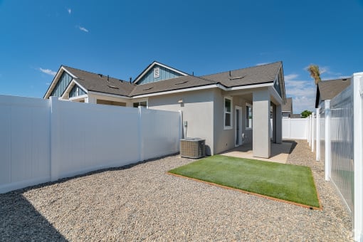 a house with a white fence and a grass yard