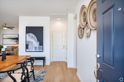 a dining room with a wooden table and chairs and a hallway with a blue door