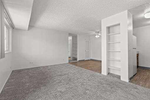 A large, empty room with a carpeted floor and white walls.