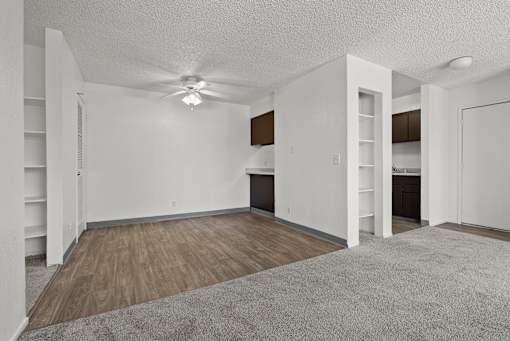 A room with a ceiling fan and wooden flooring.