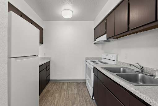A kitchen with white appliances and brown cabinets.
