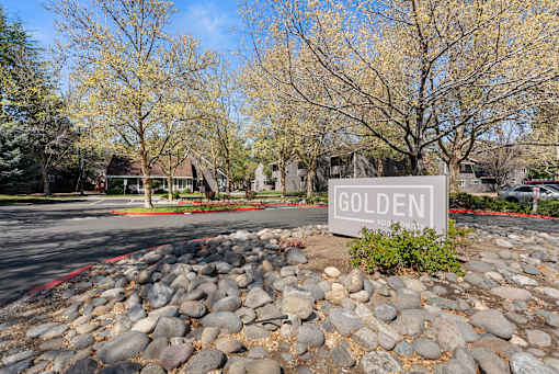A sign that says "Golden" is in front of a rocky area.