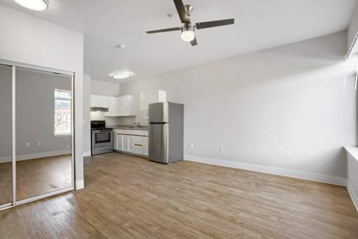 A kitchen with a refrigerator, microwave, and oven.
