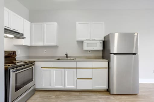 A modern kitchen with white cabinets and stainless steel appliances.