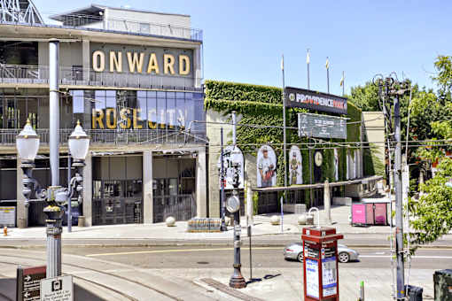 A street view of a building with a sign that reads "ONWARD ROSE CITY".