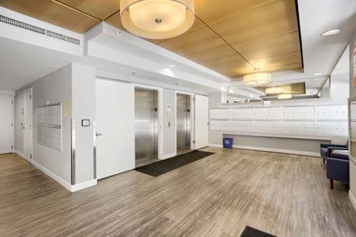 A hallway with a bench and a row of lockers.