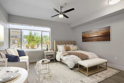 A bedroom with a large bed, a chair, and a dining table.