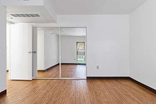 A room with white walls and wooden flooring with a sliding glass door at Pin Yuen, Sacramento, CA