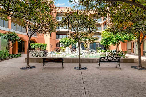 A courtyard with two benches and trees at Pin Yuen, Sacramento