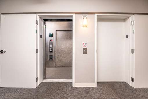 A white door with a silver elevator in the background.