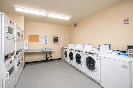 A laundry room with washing machines and a sign on the wall.