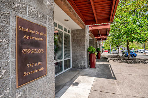 A brown sign on a building that says Stadium Station Apartments.