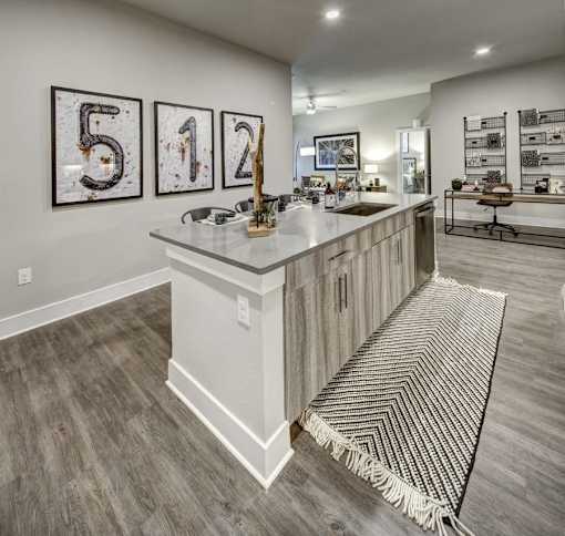 A kitchen with a white island and a rug on the floor at Arise Riverside Apartments, Austin, 78741