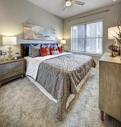 A bedroom with a large bed and a painting on the wall at Arise Riverside Apartments, Austin, Texas