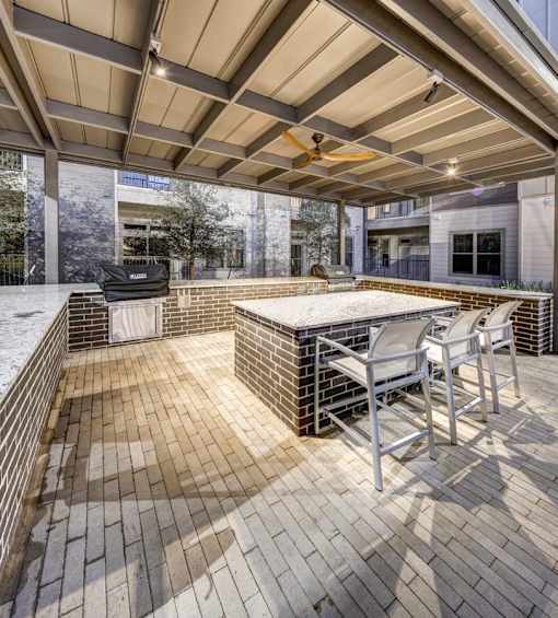 A patio with a table and chairs under a roof at Arise Riverside Apartments, Austin, TX