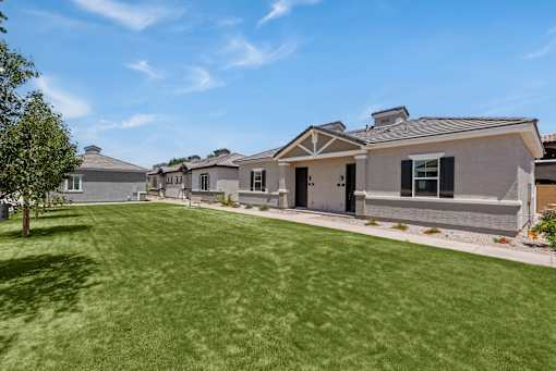 a group of houses on the side of a green lawn at Zora Encanto, Phoenix, AZ 85035