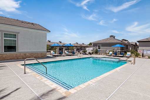 our resort style swimming pool is next to our building with umbrellas and chairs at Zora Encanto, Phoenix, AZ 85035