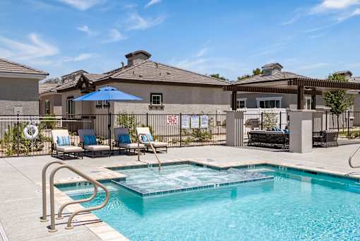 our apartments have a resort style pool with lounge chairs and umbrellas at Zora Encanto, Arizona