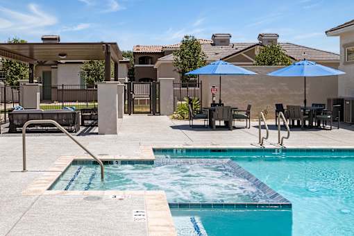 our resort style swimming pool with umbrellas and chairs at our apartments at Zora Encanto, Phoenix, 85035