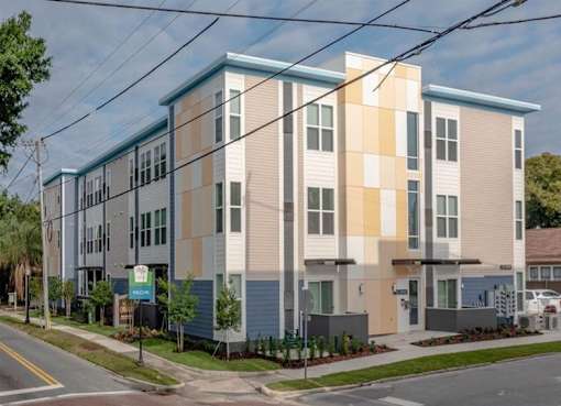 A modern apartment building with a blue and beige facade.