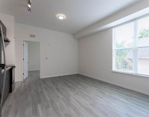 A spacious room with a grey floor and white walls.