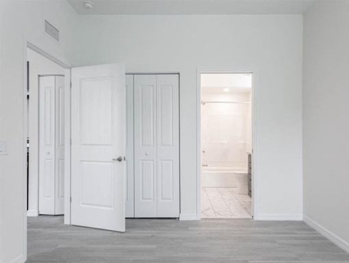 A room with white doors and a grey floor.