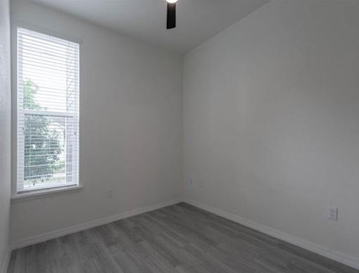 A room with a window and wooden flooring.