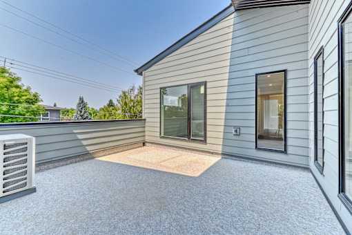 A house with a grey siding and a glass door.