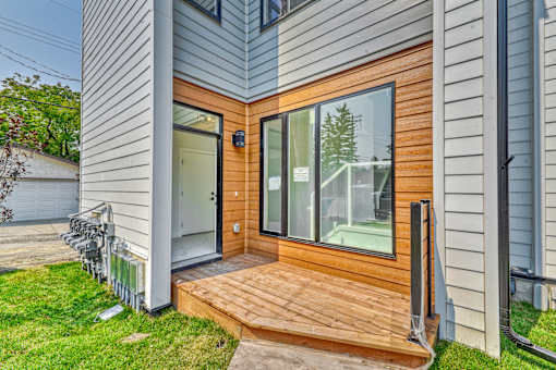 A modern house with a wooden deck and sliding glass doors.
