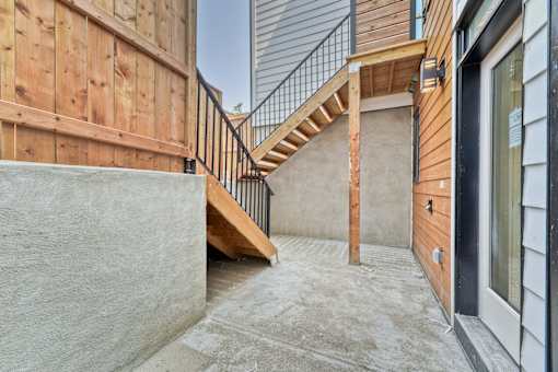 A concrete staircase leads up to a wooden deck.