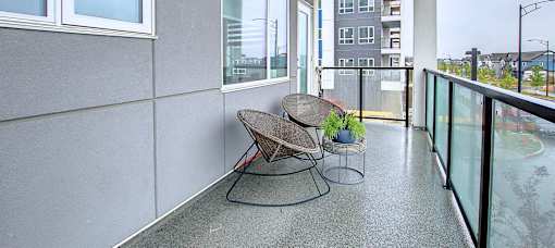 A balcony with a table and chairs.