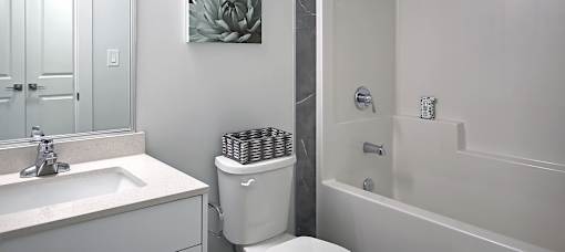 A white toilet sits next to a sink in a bathroom.