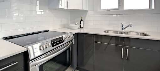 A modern kitchen with a stove top oven and a sink.