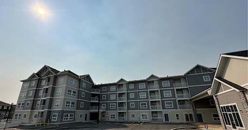 an apartment building with the sun shining over it