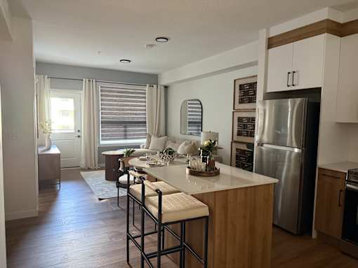 A kitchen with a bar stool and a counter.at The Pointe at Riverview, Alberta, T6M 3H4