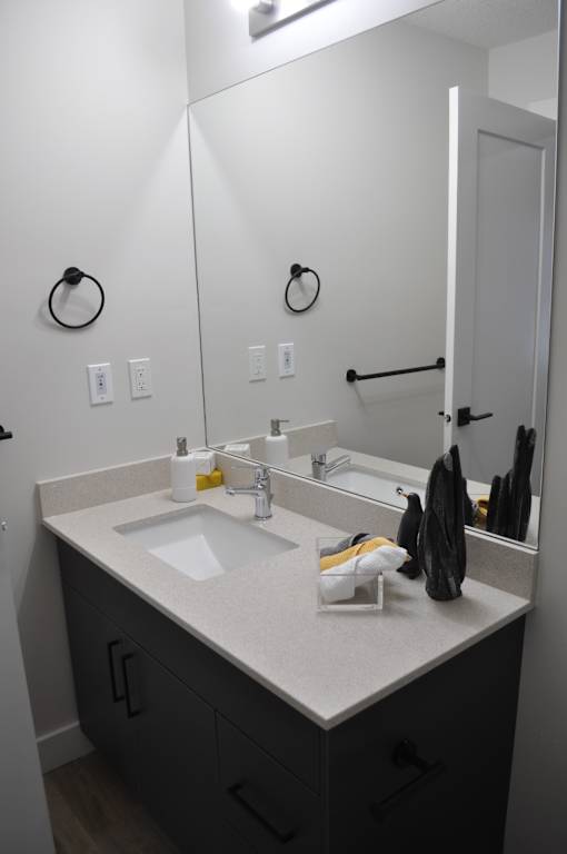 A bathroom with a sink and mirror at The Laurent at Laurel Apartments, Edmonton, AB