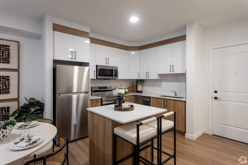 A modern kitchen with a stainless steel refrigerator, microwave, and white countertops.at The Pointe at Riverview, Edmonton Alberta