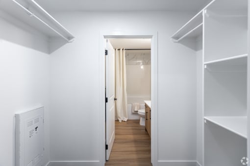 A white hallway with a doorway leading to a bathroom.at The Pointe at Riverview, Edmonton, AB