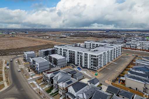 A large white building with a parking lot in front of it.at The Pointe at Riverview, Edmonton, AB