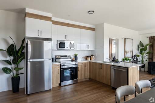 A modern kitchen with wooden cabinets and stainless steel appliances.at The Pointe at Riverview, Edmonton, AB T6M 3H4