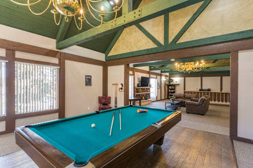 A pool table in a room with a chandelier.