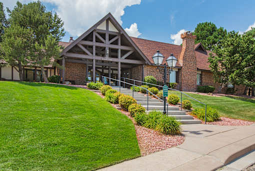 A building with a red roof and a green lawn in front.